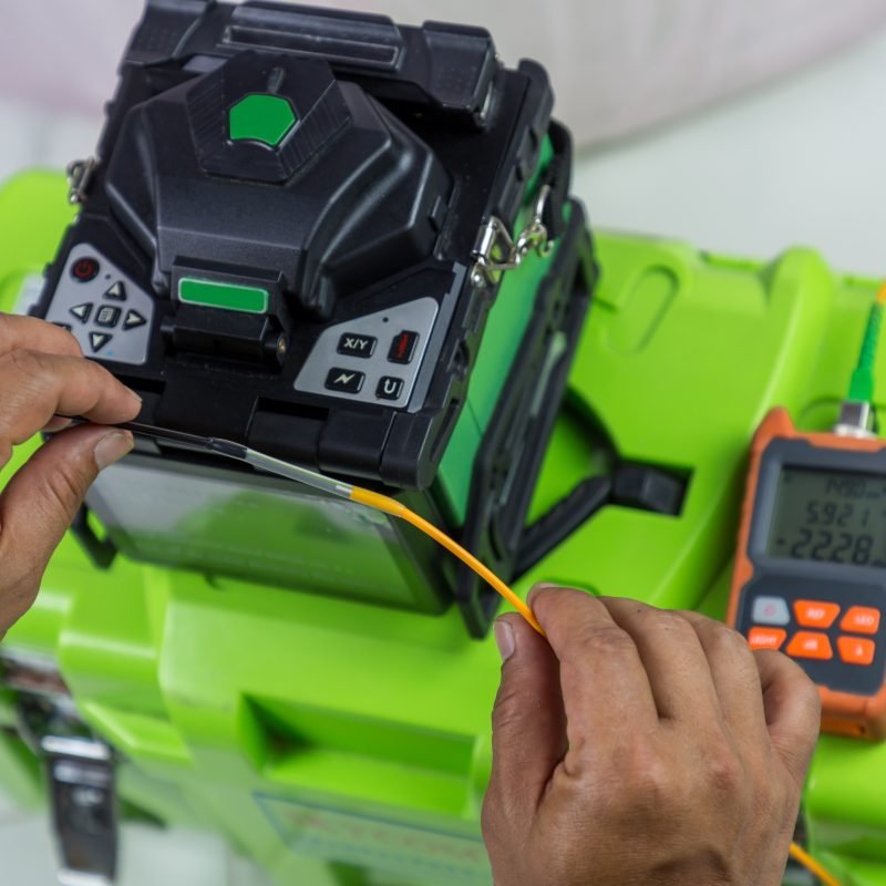 Optical fiber installation with Digital Fiber Optical Fusion Splicing machine. High precision fiber optic cleaver is being used during a fiber optic wire install at House.  Welding of optical fibers.